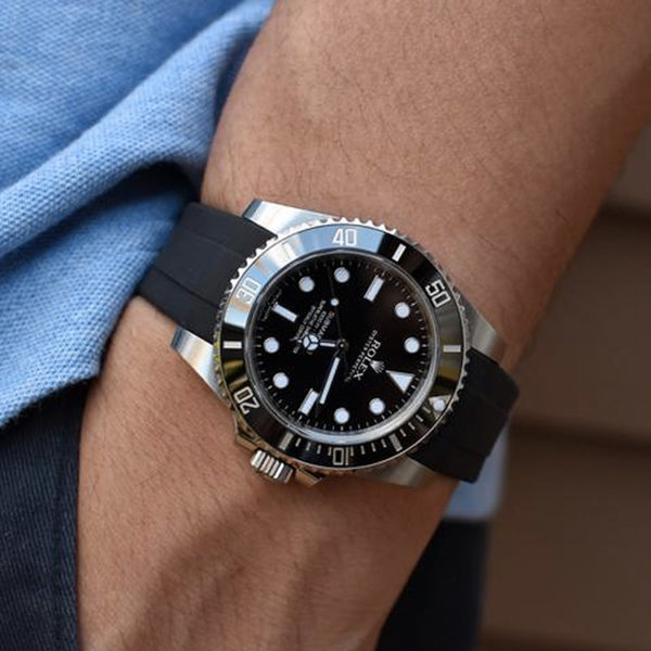 Black rubber strap with Rolex watch on wrist